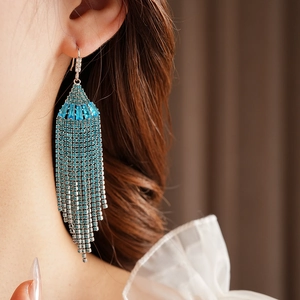 Close-up of bohemian blue zircon fan-shaped tassel earrings with sparkling rhinestones