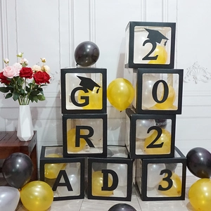 Black transparent GRAD balloon boxes with gold and white balloons for graduation party decor