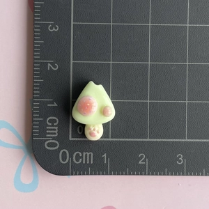 Macro view of 1.5cm resin donut accessory with paw print detail on ruler grid