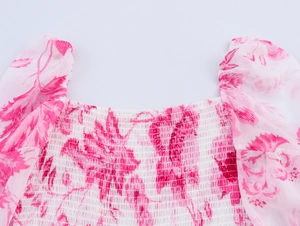 Détail du col carré avec imprimé fleuri, bustier smocké et manches bouffantes