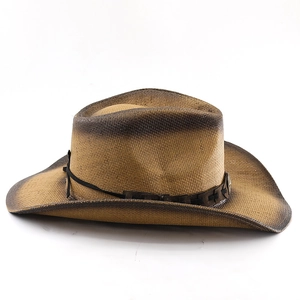 Close-up of a woven straw cowboy hat with a brown leather decorative band and gradient texture