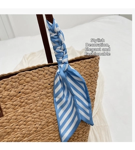 Close-up of blue and white striped silk scarf wrapped around a straw bag handle
