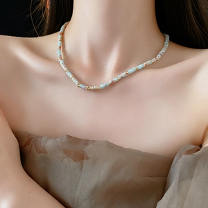Ethnic beaded Shoushan stone necklace featuring light blue and beige beads on model