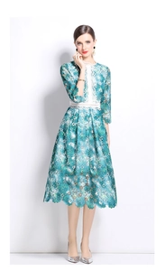 Détails de broderie en dentelle florale verte et blanche sur la robe midi