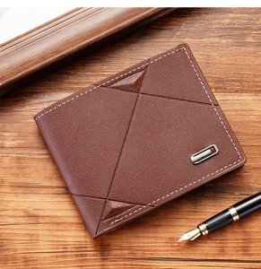 Macro detail of brown leather wallet with geometric stitching and metal logo on wood