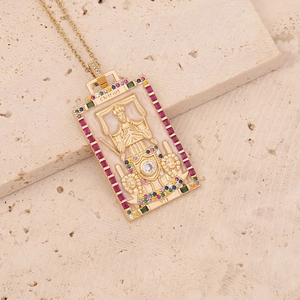 Détail du collier Tarot Chariot doré avec pierres précieuses sur fond de pierre