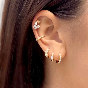 Close-up of gold plum blossom earrings set with zircons and butterfly ear studs