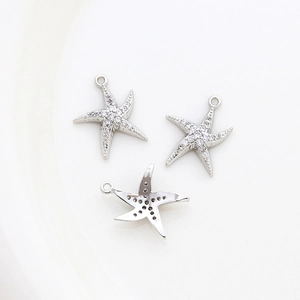 Detailed view of 14k gold-plated starfish charms with embedded sparkling gemstones
