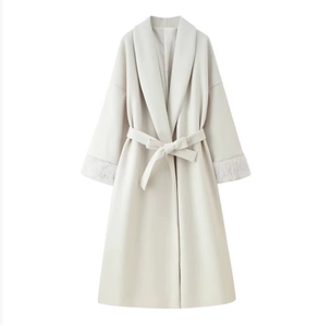 Close-up of ivory wool coat sleeve featuring luxurious faux fur cuffs and a matching belt