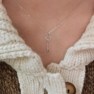 Macro detail of 925 sterling silver key pendant with twisted rope design on model