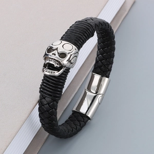 Detailed close-up of a men's braided leather bracelet with a silver skull magnetic clasp