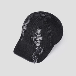 Detail of dark grey washed denim baseball cap with distressed rip and fraying effects