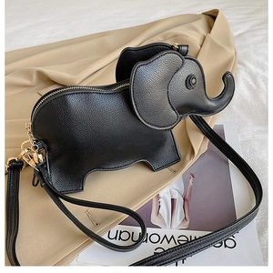 Detail of cute black elephant crossbody bag on beige fabric with adjustable strap