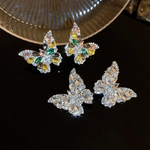Detail of butterfly drop earrings featuring sparkling rhinestones in white and rainbow colors