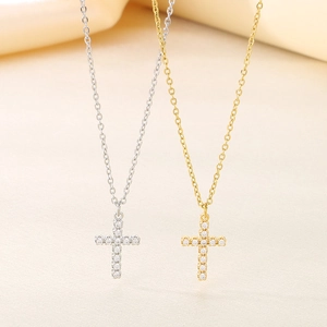 Detail of gold and silver cross necklaces with micro-paved zircons on elegant chains