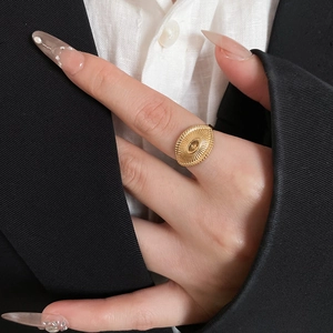 Close-up of gold oval ring with radial texture on a hand with professional business attire