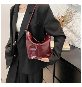Detailed view of dark red vintage faux leather shoulder bag with glossy oil wax finish