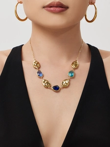 Detail of 18k gold plated necklace with teal gemstones and matching hoop earrings