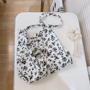 Detail view of floral cotton tote bag with a soft texture and black flower pattern