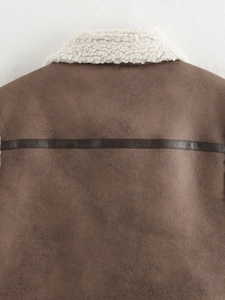 Close-up of horizontal leather stitching on brown suede vest with white shearling collar