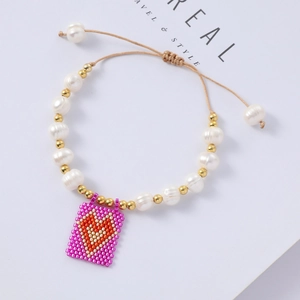 Detail of beaded heart charm bracelet with freshwater pearls and adjustable brown cord