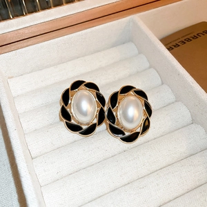 Vintage oval enamel earrings with central pearl and gold trim in a beige velvet jewelry box