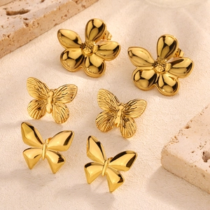 Golden butterfly and floral earring set on textured stone for a luxury look