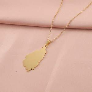 Close-up of golden stainless steel Germany map pendant necklace on soft fabric