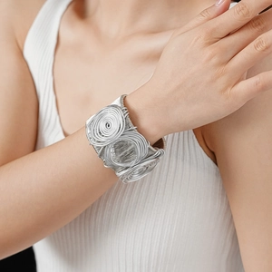 Detail of silver multilayer wire-wrapped cuff bracelet featuring spiral concentric discs