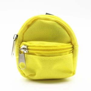 Macro detail of yellow canvas mini backpack keychain featuring double metal zippers and ring