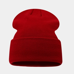Macro shot of red knit beanie texture featuring detailed fine wool weaving and cuffed edge