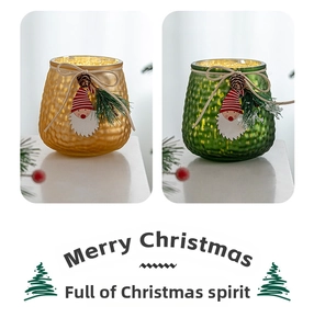 Close-up of hammer-textured Christmas glass candle holders with pine cones and festive tags
