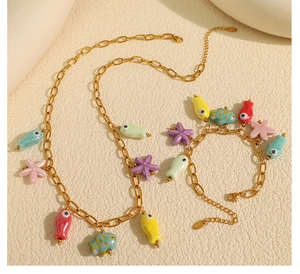 Detail of gold marine necklace set featuring colorful ceramic fish and starfish charms
