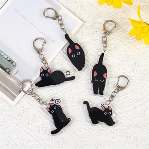 Cute cartoon black cat acrylic keychains in five poses on a white textured background