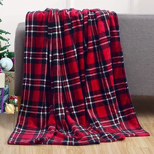Detail of red and black buffalo plaid flannel blanket draped on a sofa for Christmas decor