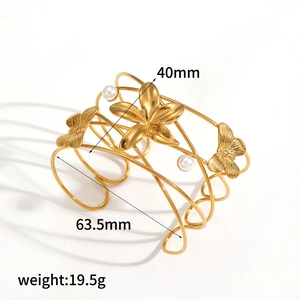 Detail view of 40mm wide gold open cuff bracelet with flower and butterfly patterns
