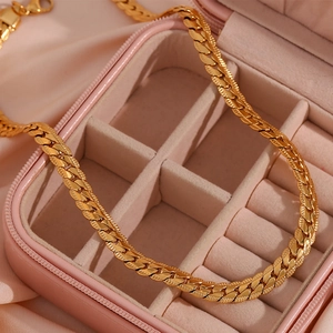 Detail of 18K gold plated Cuban link necklace with lobster clasp on pink satin