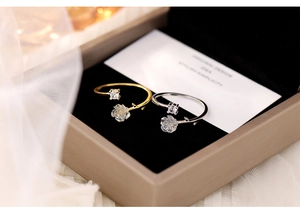 Macro detail of gold and silver camellia flower rings with crystal in a jewelry box