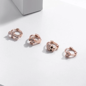 Rose gold earrings set with zircon studs in skull, heart, cross, and flower shapes