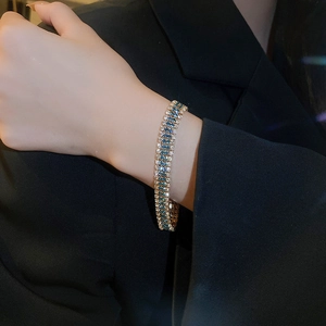 Detailed view of multi-row blue and white zircon bracelet worn on a black blazer sleeve