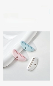 Close-up of durable ABS toothpaste squeezers in blue, pink, and white plastic finish