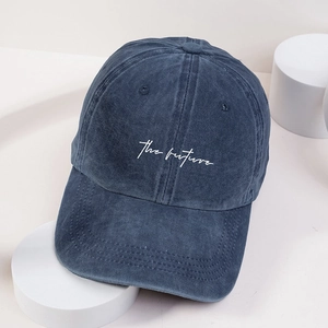 Close-up of white embroidered the future text on washed navy blue baseball cap
