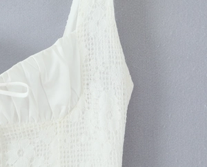 Gros plan détaillé sur le motif de dentelle blanche délicate et les coutures de la robe