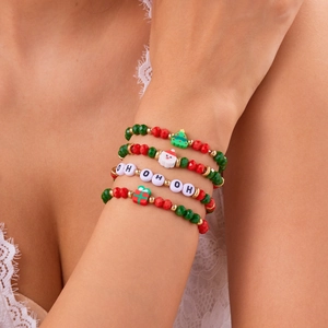 Primo piano di braccialetti natalizi con perline e ciondoli festivi sul polso