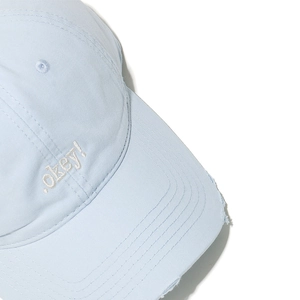 Close-up of light blue cotton baseball cap with okey! embroidery and distressed brim