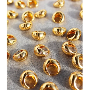 Golden chunky hoop earrings with micro-pave starburst zircon on a textured background