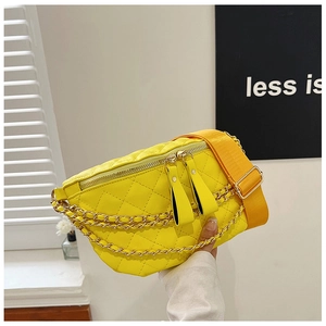 Close-up of quilted yellow crossbody bag with gold chain and dual zipper details