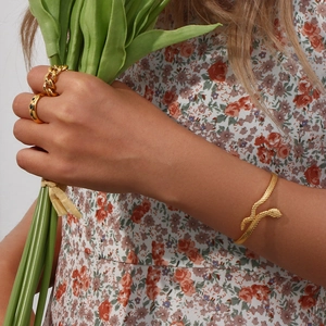 Detailed view of 18K gold plated snake bracelet and matching rings with green tulip