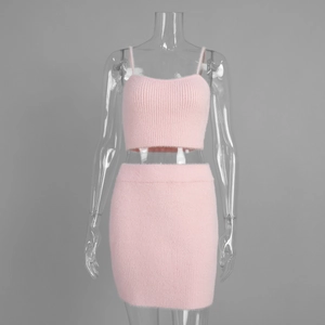 Close-up of pink fuzzy knit two-piece set featuring cropped camisole and high waist skirt