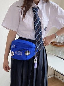 Blue canvas crossbody chest bag with astronaut pendant and decorative badges